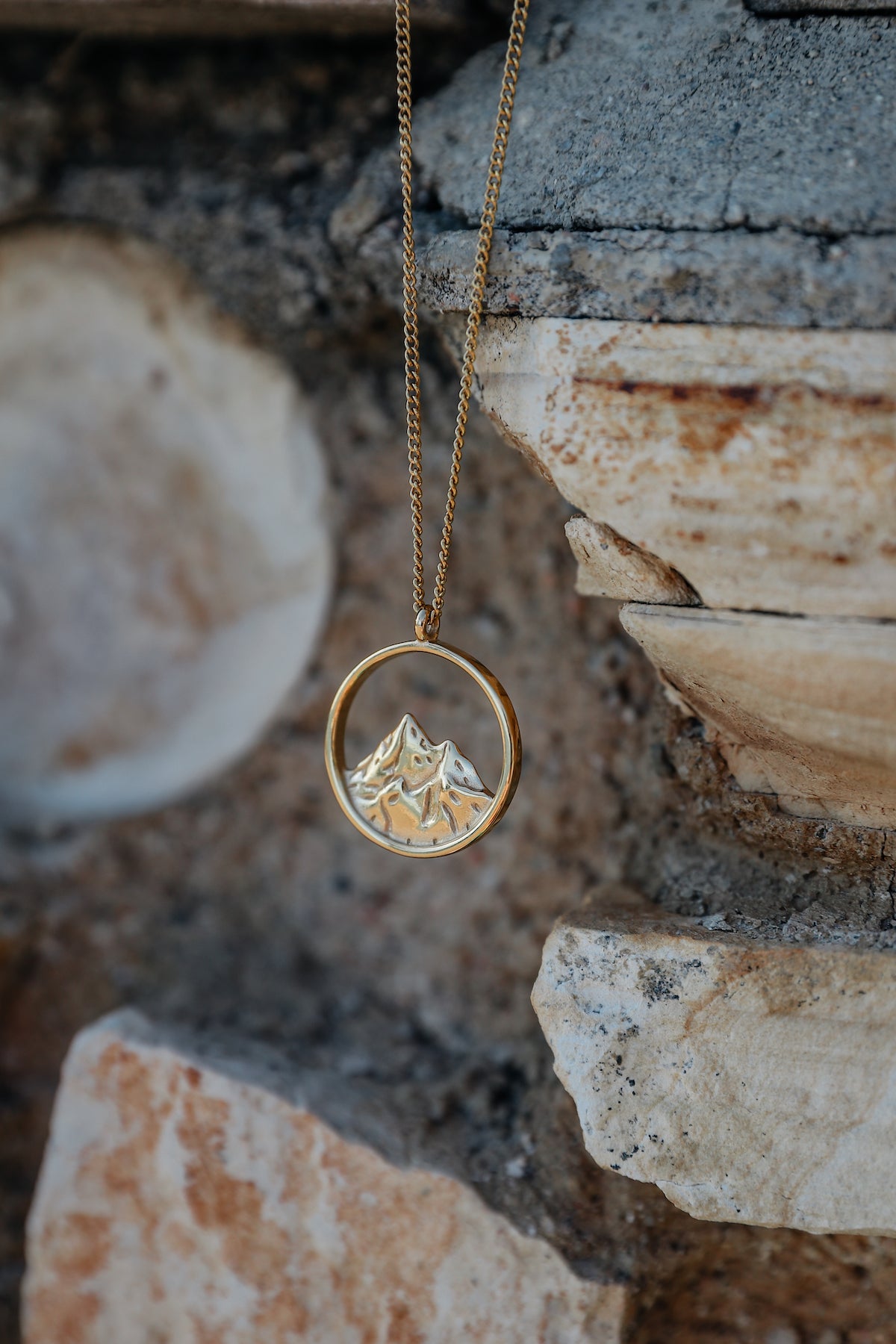 Breaking point necklace hanging from a stone backdrop