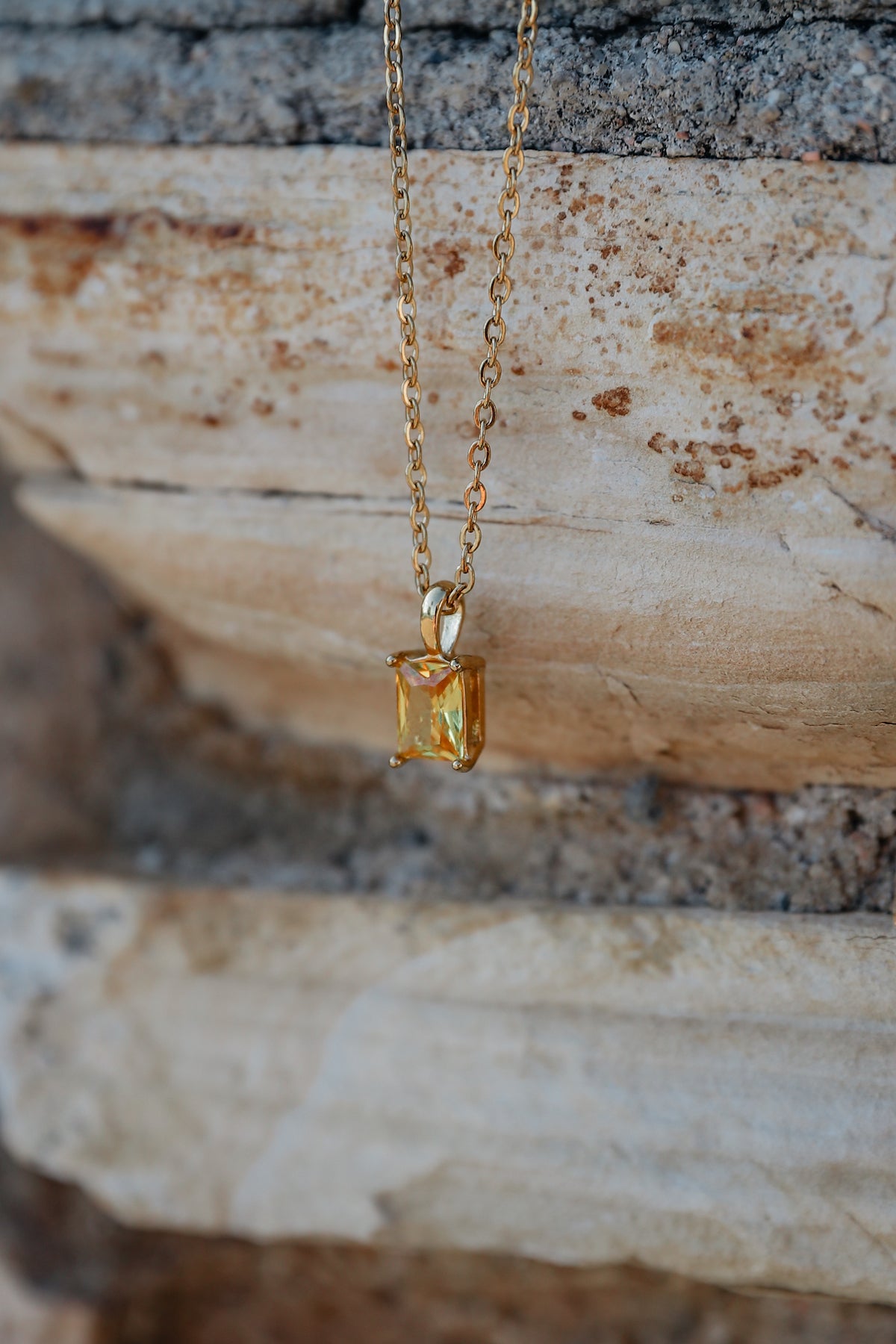Yellow crystal  The one necklace against stone backdrop