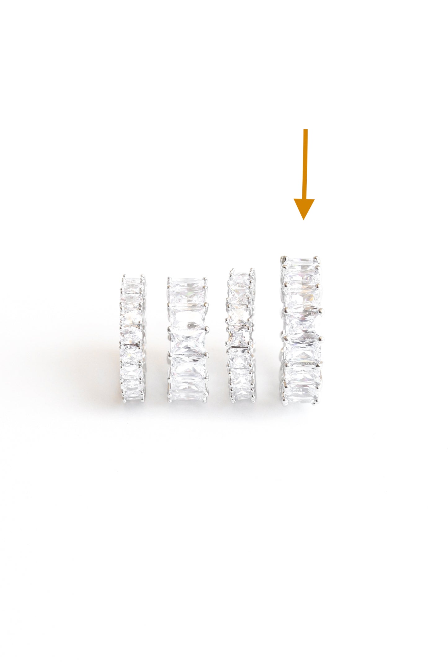 Orange arrow point to amor ice ring in  ring line up of AMOR DEUS current crystal rings