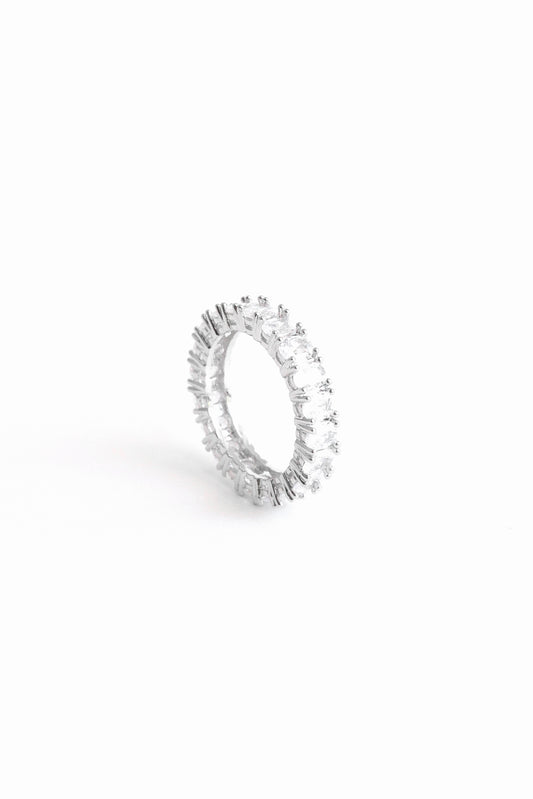 Oval Amor band ring on its side against a white backdrop