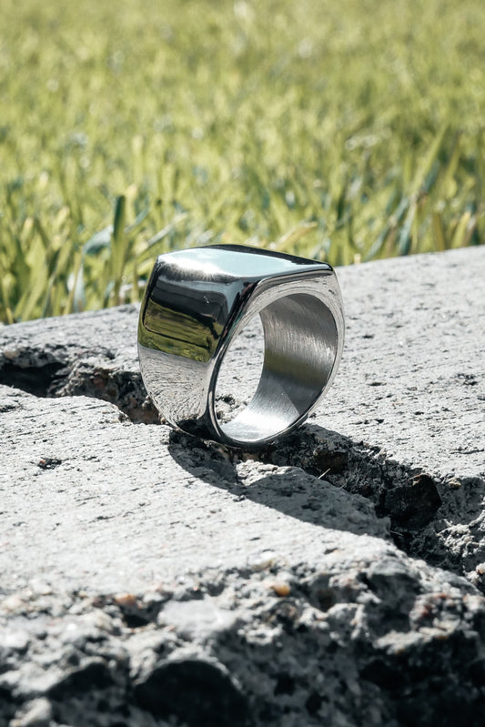 Silver Amor bold mens ring on concrete