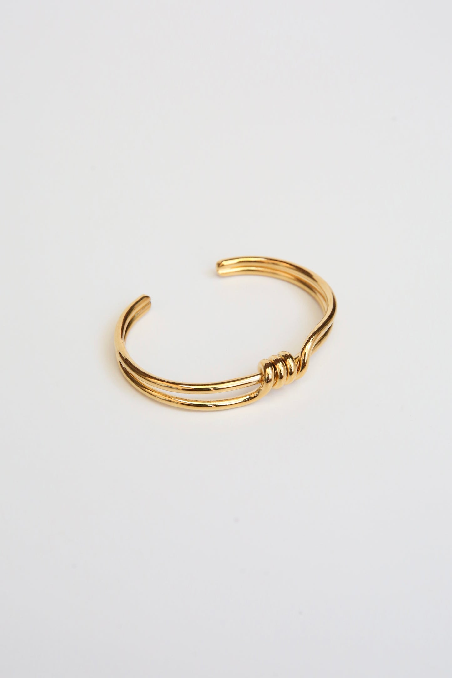 Two banded Gold surrounded bracelet with a front wrap around detail on a white background