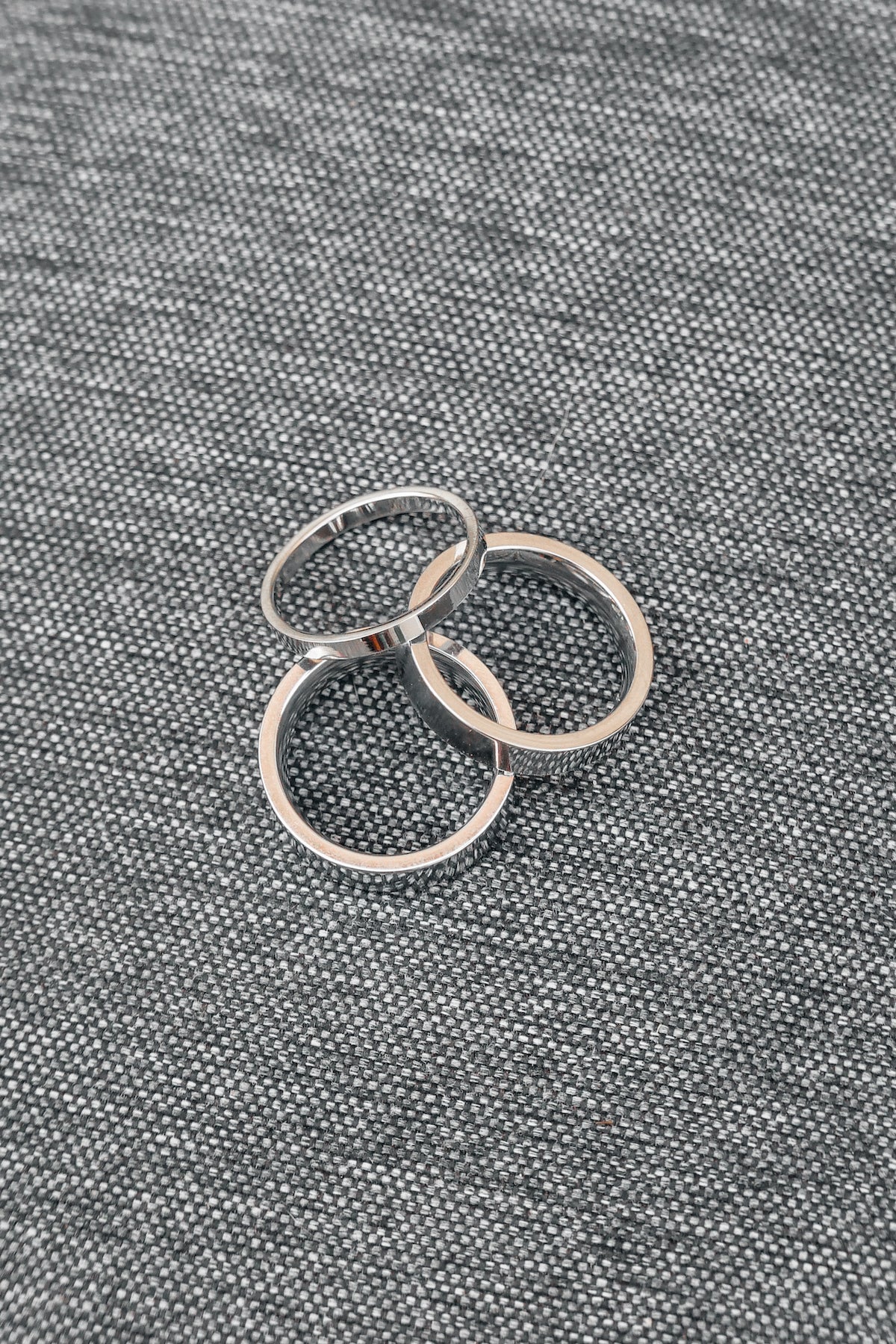 Silver banded Amor ring set on a gray backdrop