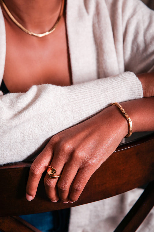 Love open ring in gold on model hand paired with gold horizon set 