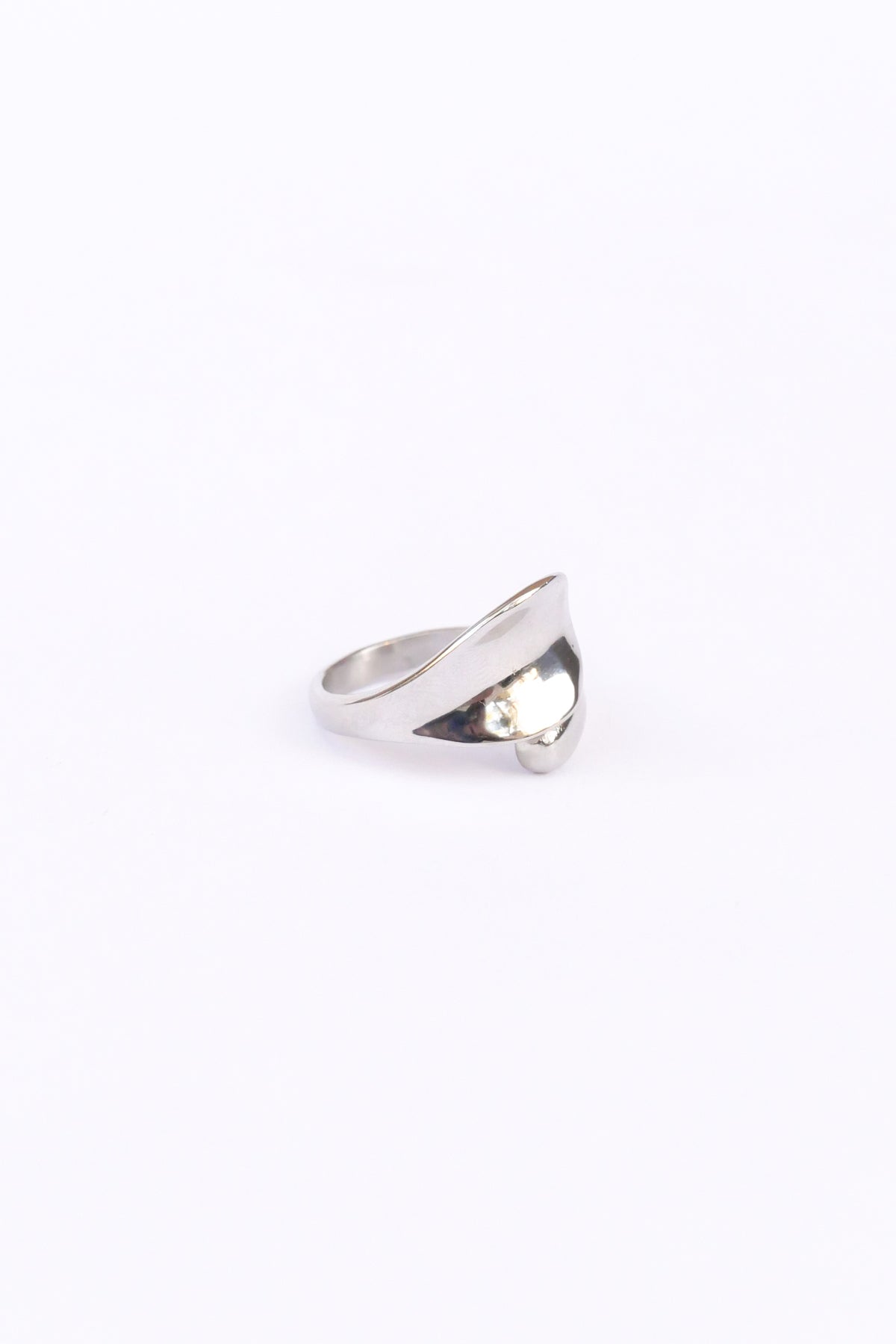 45 degree side view of silver love open ring on white backdrop