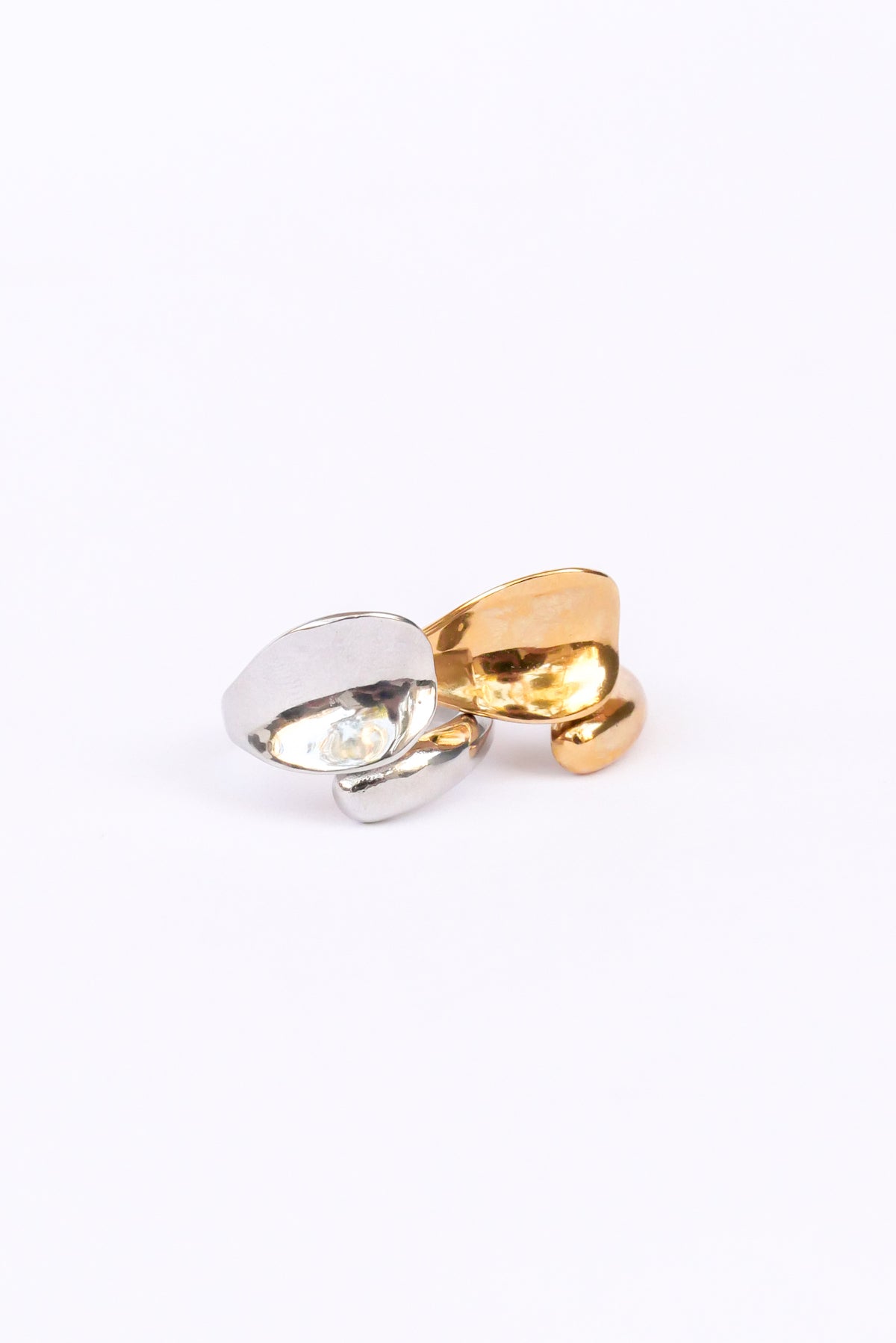 love open ring in silver and gold laying on its side against a white backdrop 